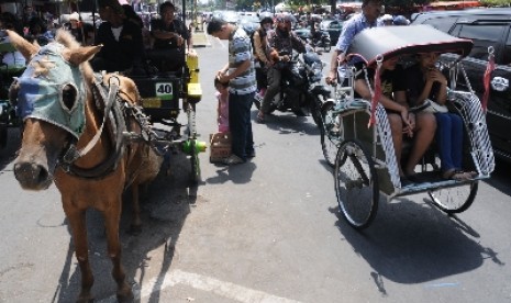 Seorang tukang becak melintas di Jalan Malioboro, Yogyakarta.