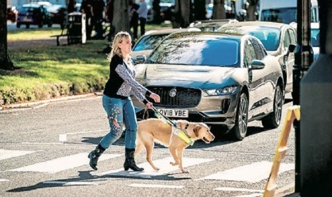 Seorang tuna netra menyeberang jalan dengan bantuan anjing. Jaguar mengembangkan sistem peringatan bagi tuna netra pejalan kaki. Sistem itu akan disematkan di kendaraan listrik mereka