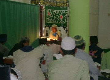 Seorang ustadz sedang mengajar ngaji.