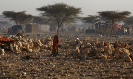 Seorang wanita berjalan di sebuah kamp yang dihuni orang-orang dari berbagai bagian di Somalia yang terganggu kehidupannya akibat kekeringan parah yang mengakibatkan kelaparan.