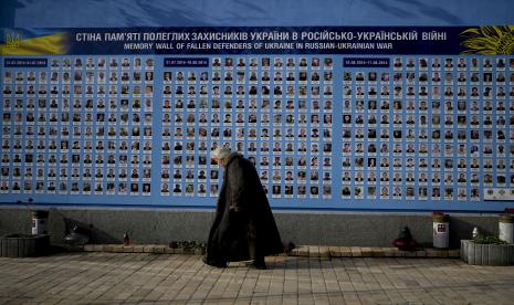 Seorang wanita berjalan melewati Tembok Peringatan Pembela Ukraina yang Jatuh dalam Perang Rusia-Ukraina di Kyiv, Ukraina, Senin, 23 Mei 2022.