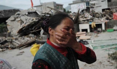 Seorang wanita desa menangis setelah rumahnya rusak akibat gempa bumi di Lushan provinsi Sichuan,Cina, Sabtu (20/4).