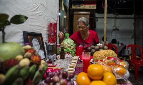 Seorang wanita keturunan etnis Tionghoa Tangerang atau Cina Benteng menyalakan hio saat merayakan  Imlek di rumahnya di kawasan Kampung Lebak Wangi, Mekarsari, Tangerang, Banten