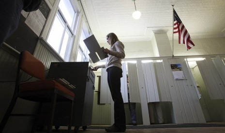  Seorang wanita memasukkan kertas suara ke dalam mesin penghitungan suara di Franconia, Minnesota, Rabu (6/11). (Reuters/Eric Miller)