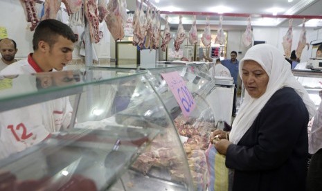 Seorang wanita membeli daging pada hari pertama bulan suci Ramadhan di pusat kota Algiers, Aljazair, Ahad  (29/6).  (Reuters/Louafi Larbi)