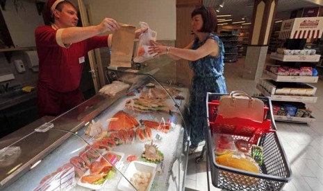 Seorang wanita membeli ikan di sebuah supermarket di St. Petersburg, Rusia, Kamis (7/8). 