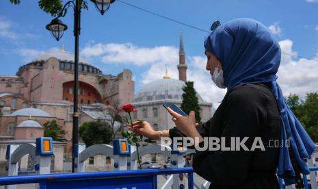 Terdapat 8 pesan simbolis politik Turki Erdogan dari konversi Hagia Sophia.  Seorang wanita menaruh bunga mawar di depan Masjid Hagia Sophia.