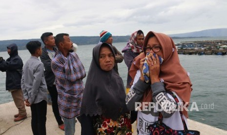 Seorang wanita mencium baju anaknya, penumpang KM Sinar Bangun, yang tenggelam di Danau Toba, Simalungun, Sumatra Utara, Selasa (19/6).