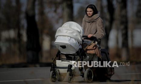 Seorang ibu mendorong kereta bayi. Kenali gejala baby blues dan postpartum syndrome.