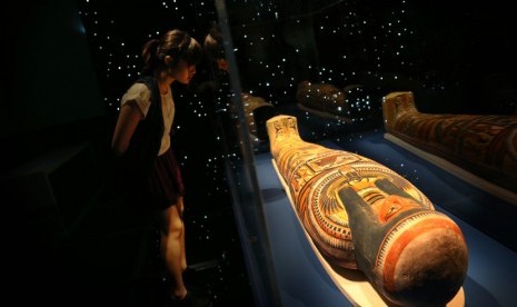 Seorang wanita mengamati sebuah Mummy dari Nesperennub, seorang pendeta kuil Mesir kuno yang hidup tiga ribu tahun yang lalu, dalam pameran di Museum ArtScience di Singapura, Kamis (25/4).  (AP/Wong Maye-E)