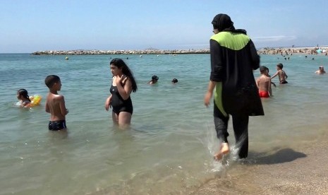 Seorang wanita mengenakan burkini atau istilah untuk baju renang yang tertutup penuh di Marseille, Prancis Selatan.