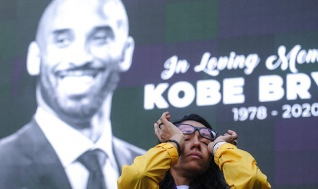 Seorang wanita menghapus air matanya saat berkumpul di Staples Center Los Angeles, Senin (27/1) waktu AS, untuk mengenang kepergian Kobe Bryant.