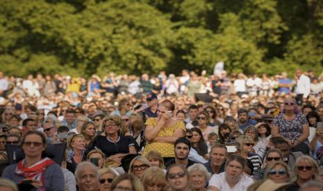 Seorang wanita menyeka air mata saat ia bergabung dengan orang-orang yang duduk di Hyde Park, London, Rabu, 14 September 2022 menonton layar yang menyiarkan prosesi peti mati Ratu Elizabeth II dari Istana Buckingham ke Westminster Hall. Ratu akan disemayamkan di Westminster Hall selama empat hari penuh sebelum pemakamannya pada Senin 19 September.