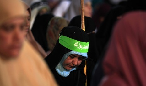 Seorang wanita Mesir tengah melaksanakan sholat saat bergabung dengan aksi unjuk rasa menolak kudeta dan mendukung Presiden Mursi di luar Masjid Rabiah Al Adawiyah, Nasr City, Kairo, Rabu (31/7).   (AP / Khalil Hamra)