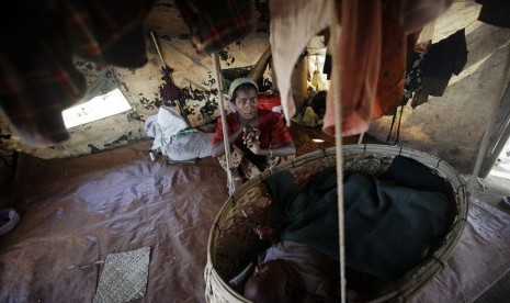  Seorang wanita muslim duduk dengan bayinya di sebuah kamp pengungsi bagi mereka yang terlantar akibat aksi kekerasan awal tahun ini luar Sittwe,  Myanmar,  Selasa (30/10).   (Soe Zeya Tun/Reuters)