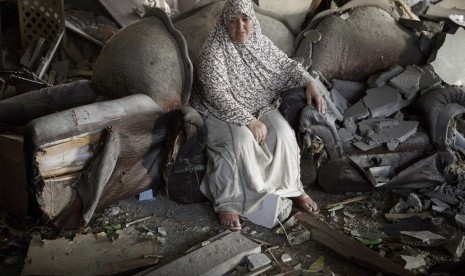  Seorang wanita Palestina duduk di dalam rumahnya yang hancur akibat serangan udara Israel, di Kota Gaza, Kamis (17/7).  (Reuters/Finbarr O'Reilly)