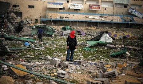  Seorang wanita Palestina menyaksikan reruntuhan stadion sepak bola, yang hancur akibat serangan udara Israel selama konflik delapan hari di Kota Gaza,Selasa (4/12). (Reuters/Suhaib Salem)