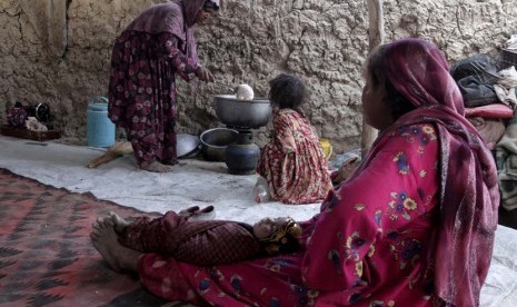 Seorang wanita pengungsi Afghanistan memasak makanan untuk berbuka puasa di Kabul, Afghanistan, Senin (22/7). (AP/Rahmat Gul)