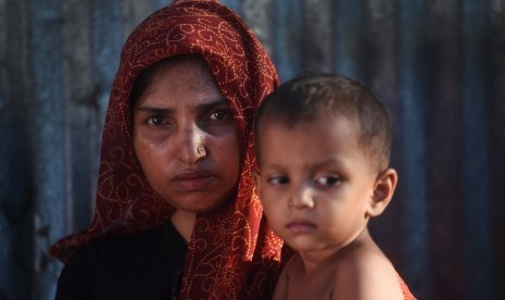 Seorang wanita pengungsi Rohingya menggendong anaknya di Kamp Pengungsian Kutupalong, Cox Bazar, Bangladesh, Minggu (1/10).