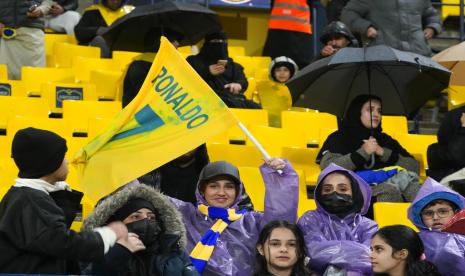  Seorang wanita Saudi memegang bendera dengan kaos Cristiano Ronaldo, anggota baru klub sepak bola Al Nassr, saat menghadiri pertandingan timnya melawan Al Tai di Liga Saudi di Marsool Park di Riyadh, Arab Saudi, Jumat (6/1/2023).