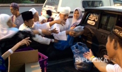  Seorang warga Arab Saudi membagi-bagikan roti dan kari kambing di depan hotel yang dihuni jamaah haji Indonesia usai shalat subuh, Senin (28/8). Pembagian itu disambut antusiasme jamaah. Mereka langsung menyerbu makanan yang dibawa dengan mobil pikap. 