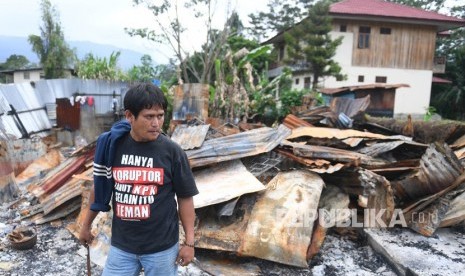 Seorang warga berada di puing rumahnya yang terbakar di kawasan Hom-hom, Kota Wamena, Kabupaten Jayawijaya, Papua, Sabtu (12/10/2019). 