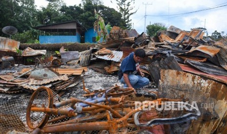 Seorang warga berada di puing rumahnya yang terbakar di kawasan Hom-hom, Kota Wamena, Kabupaten Jayawijaya, Papua, Sabtu (12/10/2019).