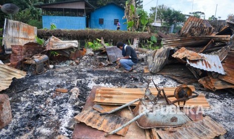 Seorang warga berada di puing rumahnya yang terbakar di kawasan Hom-hom, Kota Wamena, Kabupaten Jayawijaya, Papua, Sabtu (12/10/2019). Wakil Menteri PUPR John Wempi Wetipo(JWW) mengatakan hingga kini baru 10 rumah toko (ruko) yang dibangun pascakerusuhan Wamena. 