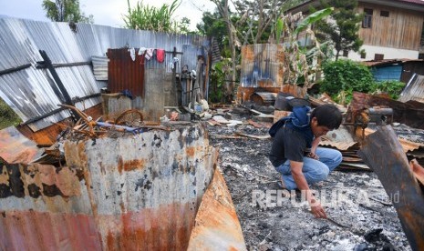 Seorang warga berada di puing rumahnya yang terbakar di kawasan Hom-hom, Kota Wamena, Kabupaten Jayawijaya, Papua, Sabtu (12/10/2019). 