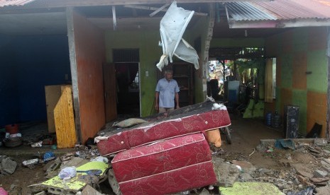 Seorang warga berada di rumahnya yang rusak akibat luapan air banjir kanal bandar bakali di kelurahan Alai Parak Kopi, Padang, Sumatera Barat, Sabtu (3/11/2018). 