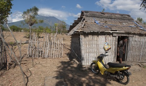 Seorang warga beraktivitas di rumahnya yang berjarak sekitar 10 kilometer dari Gunung Agung yang berstatus awas di Desa Datah, Karangasem, Bali, Selasa (26/9). 