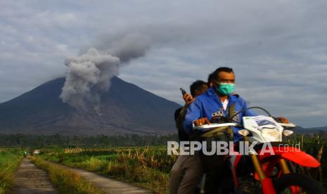 Seorang warga berbegas menuju pengungsian saat terjadi luncuran awan panas dari gunung Semeru di desa Supiturang, Pronojiwo, Lumajang, Jawa Timur, Selasa (7/12/2021). Pusat Vulkanologi Mitigasi Bencana Geologi (PVMBG) menghimbau masyarakat agar mewaspadai awan panas serta tidak beraktivitas dalam radius satu kilometer dari kawah gunung dan lima kilometer dari arah bukaan kawah di sektor tenggara - selatan.