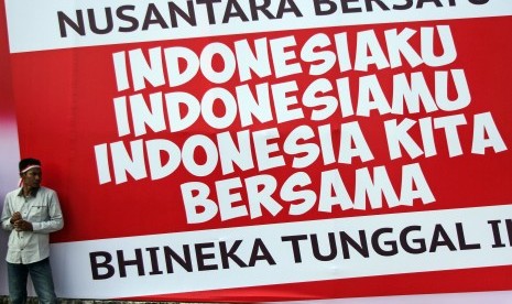 Seorang warga berdiri di depan spanduk Nusantara Bersatu ketika mengikuti rangkaian acara Nusantara Bersatu di Pekanbaru, Riau, Rabu (30/11). 