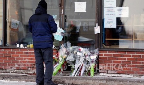 Seorang warga berdiri di toko kelontong milik Azzeddine Soufiane salah satu korban penembakan di Masjid di Pusat Kebudayaan Islam Quebec, Quebec City, Kanada.