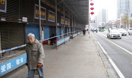 Seorang warga berjalan di pasar hidangan laut Huanan di Wuhan, China. Pemerintah China pada Senin (20/1) melaporkan peningkatan tajam jumlah penderita pneumonia akibat virus korona.