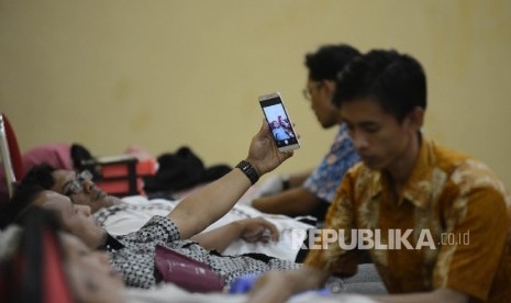 Seorang warga berswafoto saat mendonorkan darahnya di Masjid Agung At-tin, Jakarta Timur, Jumat (31/12). 