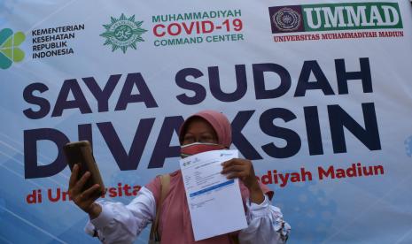 Seorang warga berswafoto seusai menerima suntikan vaksin saat vaksinasi massal Covid-19.