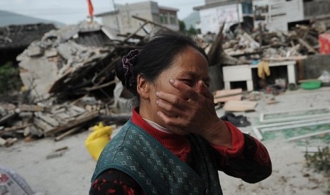  Seorang warga Cina menangis mendapati rumahnya rusak berat akibat gempa yang melanda Ya'an, Provinsi Sichuan, Cina, Sabtu (20/4) waktu setempat. 