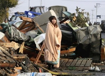 Seorang warga Jepang berdiri terpaku usai gempa tsunami menerjang Jepang pada Maret lalu.