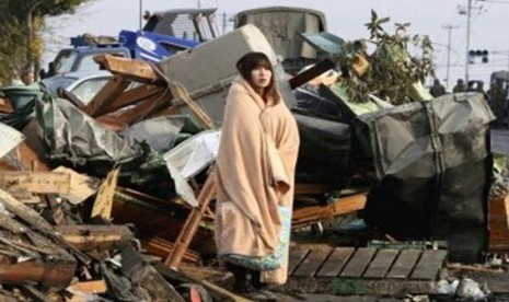 Seorang warga Jepang berdiri terpaku usai gempa tsunami menerjang Jepang pada Maret lalu.