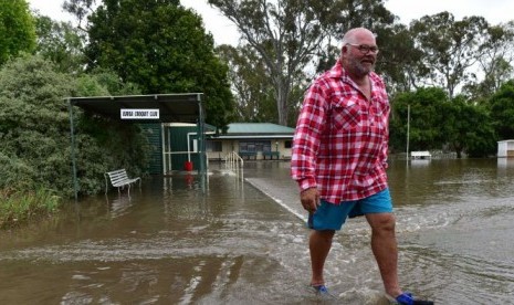 Seorang warga lokal melewati genangan air di kawasan Euroa, Victoria, Australia, Sabtu (2/12).