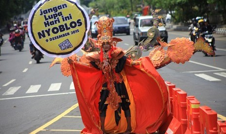 Seorang warga melakukan kampanye partisipasi Pilkada di Jalan Jendral Sudirman, Solo, Jawa Tengah, Rabu (9/12).