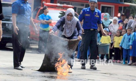 Seorang warga melakukan simulasi penanganan kebakaran di halaman kantor Pemadam Kebakaran, Jl Sukabumi, Kota Bandung, Rabu (30/3). Simulasi digelar sebagai tindakan pertama pencegahan kebakaran dan meningkatkan kewaspadaan akan bencana kebakaran.