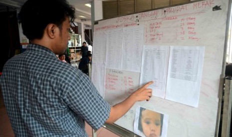 Seorang warga melihat data nama-nama korban dalam kecelakaan kapal Bahuga Jaya dengan Kapal Kargo di pelabuhan Merak, Banten, Rabu (26/9)