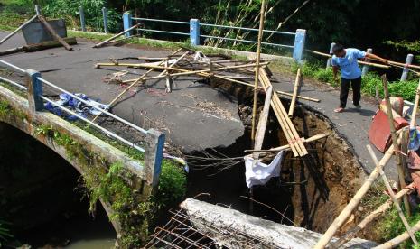 Seorang warga melihat jembatan yang amblas di Gebyak, Singosari, Malang, Jawa Timur, Sabtu (18/6/2022). Jembatan yang merupakan penghubung jalur alternatif untuk mengangkut hasil pertanian antara Malang dan Kota Batu tersebut sudah empat bulan amblas dan tak kunjung diperbaiki. 