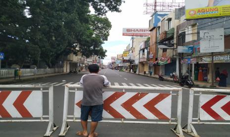 Seorang warga melihat kondisi Jalan HZ Mustofa Kota Tasikmalaya yang sepi karena ditutup, Selasa (31/3). Jumlah pasien positif Covid-19 di Kota Tasikmalaya terus meningkat dari hari ke hari. Hingga Ahad (19/4), total kasus pasien positif di kota santri itu mencapai 27 orang. 