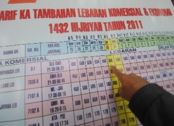 Seorang warga melihat poster jadwal dan tarif kereta api (KA) tambahan Lebaran 2011 di Stasiun Jatinegara, Jakarta.