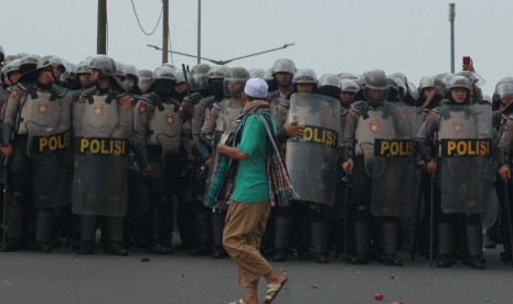 Seorang warga melintas di depan blokade kepolisian di atas jalan layang Slipi Jaya, Jakarta, Rabu (22/5/2019).