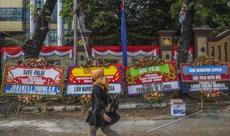 Seorang warga melintas di depan Mabes Polri yang dipenuhi karangan bunga di Jalan Trunojoyo, Jakarta, Senin (8/8/2022). Karangan bunga yang dikirim oleh berbagai pihak dan elemen masyarakat itu sebagai wujud dukungan kepada Polri untuk mengungkap kasus tewasnya Brigadir Nofriansyah Yoshua Hutabarat atau Brigadir J secara tuntas dan transparan. 