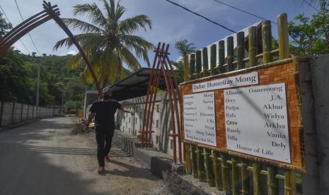 Seorang warga melintas di gerbang kampung homestay Mong di kawasan wisata Kuta Mandalika, Desa Kuta, Kecamatan Pujut, Praya, Lombok Tengah, NTB, Sabtu (5/3/2022). Menurut data Dinas Pariwisata Provinsi NTB per tanggal (4/3/2022) sebanyak 7.315 kamar penginapan masih tersedia dan belum dipesan untuk gelaran MotoGP yang terdiri dari hotel berbintang, bungalow, homestay, hotel melati, rusun dan sarana hunian pariwisata (Sarhunta) yang tersebar di Pulau Lombok. 10 Ribu Tiket MotoGP untuk ASN dan Warga NTB Didiskon 80 Persen